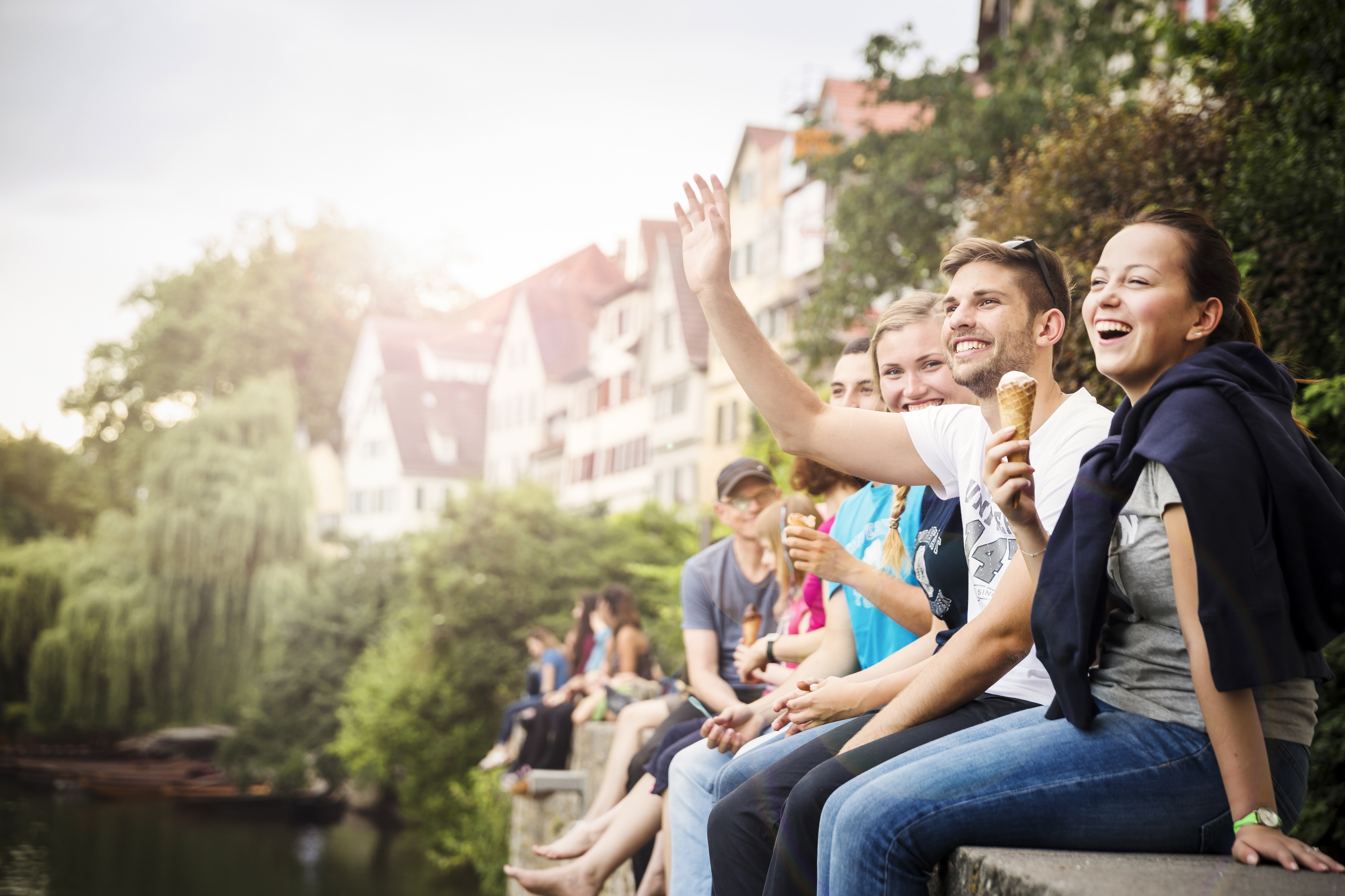 Students sitting on a wall next to the Neckar river
