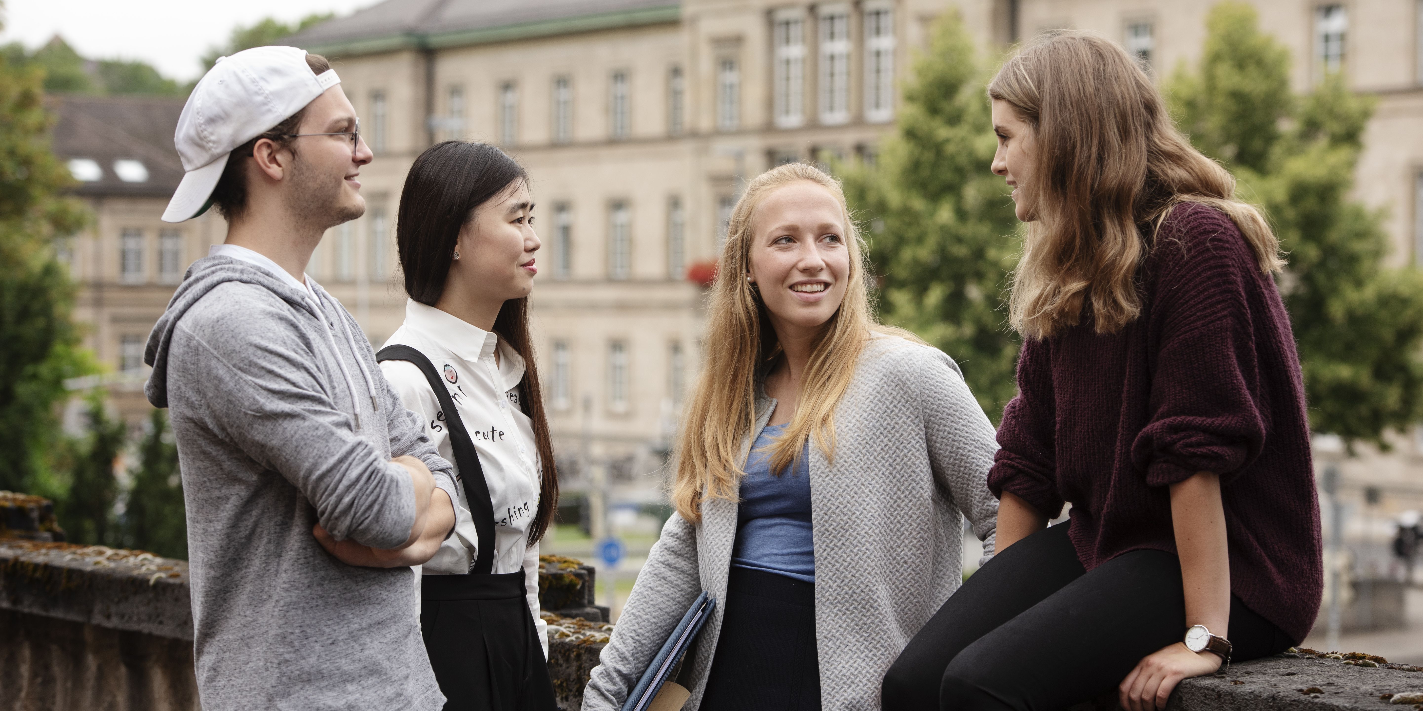 Students in conversation in front of the Neue Aula building